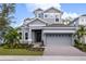 Two-story home with gray siding, a three-car garage, and landscaping at 1003 Signet Dr, Apollo Beach, FL 33572