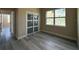 This is an empty bedroom with light wood-look floors, a sliding closet, and a bright window at 1504 Kohlenberg Ave, North Port, FL 34288