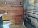 Charming bathroom featuring wood walls, toilet, and shower with artistic shower curtain at 718 New York St, Clearwater, FL 33756