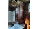 Bathroom with wood-paneled walls, a vanity with a large mirror, and a shower at 718 New York St, Clearwater, FL 33756