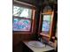 Bathroom featuring decorative privacy window, wood trim, bamboo frame mirror, and sink at 718 New York St, Clearwater, FL 33756