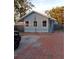 Charming bungalow with gray siding, brick driveway, and mature trees at 718 New York St, Clearwater, FL 33756