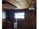 View of the living room with wood walls, decorative ceiling and fan, and window with bright light at 718 New York St, Clearwater, FL 33756