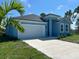 Newly built light blue house, two-car garage, and landscaping at 7340 Bass St, Englewood, FL 34224