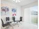 Modern dining room with glass table and four chairs, and backyard view at 9474 Sanders Park Pl, Seffner, FL 33584