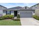 Curb appeal abounds in this charming one-story home, featuring a gray exterior and lush landscaping at 9474 Sanders Park Pl, Seffner, FL 33584