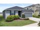 Landscaped front yard and gray exterior create inviting curb appeal for this single story home at 9474 Sanders Park Pl, Seffner, FL 33584