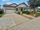 Front view of a house with a two-car garage and manicured landscaping at 8955 Garden Party Dr, Land O Lakes, FL 34637