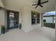 Inviting front porch with modern door and ceiling fan at 8955 Garden Party Dr, Land O Lakes, FL 34637