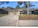 House exterior featuring a two-car garage and well-maintained lawn at 12600 Jillian Cir, Hudson, FL 34669