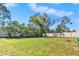 Large backyard with grassy area, trees, and privacy fence at 13474 Tune Ln, Spring Hill, FL 34609