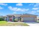 One-story home with gray exterior, red door, and two-car garage at 13474 Tune Ln, Spring Hill, FL 34609