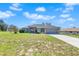 House exterior with gray siding, red door and attached garage at 13474 Tune Ln, Spring Hill, FL 34609