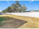 Backyard with grassy area and a white fence at 6941 Twilite Dr, Port Richey, FL 34668