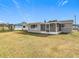 Home exterior view showcasing backyard and screened porch at 6941 Twilite Dr, Port Richey, FL 34668