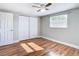 Bright bedroom with wood-look floors, ceiling fan, and double-door closet at 6941 Twilite Dr, Port Richey, FL 34668