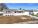 Newly renovated single-story home with a gray exterior, white garage door, and landscaped lawn at 6941 Twilite Dr, Port Richey, FL 34668