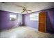 Empty bedroom with purple walls, ceiling fan, and wood closet at 4119 Beacon Square Dr, Holiday, FL 34691