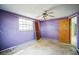 Empty bedroom with purple walls, ceiling fan, and wood closet at 4119 Beacon Square Dr, Holiday, FL 34691