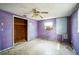 Empty bedroom with purple walls, ceiling fan, and wood closet at 4119 Beacon Square Dr, Holiday, FL 34691