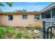 Side of house showing exterior wall and overgrown yard at 4119 Beacon Square Dr, Holiday, FL 34691