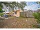 Side yard with overgrown grass and wooden fence at 4119 Beacon Square Dr, Holiday, FL 34691