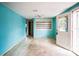 Empty living room with light blue walls, built-in shelving, and access to exterior at 4119 Beacon Square Dr, Holiday, FL 34691