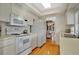 Galley kitchen with white appliances and wood floors at 7213 19Th W Ave, Bradenton, FL 34209