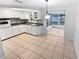 Kitchen and sunroom view with white cabinets and tile floor at 1414 Wickham Ln, Holiday, FL 34691
