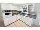 Recently updated kitchen features white cabinets, gray countertops, and modern appliances at 1414 Wickham Ln, Holiday, FL 34691