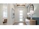 Bright and airy entryway with modern console table and view to bedroom at 14451 Coastal Woodland Ln, Parrish, FL 34219