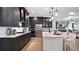 Spacious kitchen featuring dark cabinetry, quartz countertops, and stainless steel appliances at 14451 Coastal Woodland Ln, Parrish, FL 34219