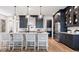 Modern kitchen with an island, white quartz countertops and dark cabinetry at 14451 Coastal Woodland Ln, Parrish, FL 34219