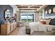 Bright main bedroom featuring wood beams, water views, and stylish decor at 14451 Coastal Woodland Ln, Parrish, FL 34219