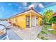 Yellow building exterior with parking and landscaping at 2600 N Paula Dr # 19A, Dunedin, FL 34698