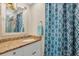 Bathroom with granite countertop, shower, and patterned curtain at 11511 113Th St # 13F, Seminole, FL 33778