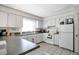 Modern kitchen with white cabinets, dark countertops, and appliances at 11511 113Th St # 13F, Seminole, FL 33778