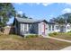 Gray house with red door, small porch, and well-maintained lawn at 2011 Dartmouth N Ave, St Petersburg, FL 33713