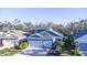 Blue house with a two-car garage and surrounding homes at 3514 Shimmering Oaks Dr, Parrish, FL 34219
