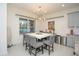 Modern dining room with a large square table and chandelier at 3514 Shimmering Oaks Dr, Parrish, FL 34219