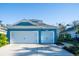 Two-story house with blue siding, two-car garage, and landscaping at 3514 Shimmering Oaks Dr, Parrish, FL 34219