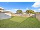 Large backyard with a grassy area and a wooden privacy fence at 4406 Woodtrail Blvd, New Port Richey, FL 34653