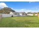 Spacious backyard with a large grassy area and a white vinyl fence at 4406 Woodtrail Blvd, New Port Richey, FL 34653