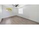 Simple bedroom with wood flooring and a window at 4406 Woodtrail Blvd, New Port Richey, FL 34653