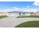 House with a white exterior, attached garage, and a neatly landscaped lawn at 4406 Woodtrail Blvd, New Port Richey, FL 34653