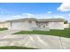 Ranch-style home with a white exterior, attached garage, and well-maintained lawn at 4406 Woodtrail Blvd, New Port Richey, FL 34653