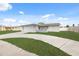 Single-story home with a white exterior, attached garage and spacious driveway at 4406 Woodtrail Blvd, New Port Richey, FL 34653