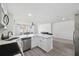 Modern kitchen with white cabinets, quartz countertops, and island at 4406 Woodtrail Blvd, New Port Richey, FL 34653