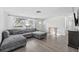 Living room with L-shaped sectional sofa and large window at 4406 Woodtrail Blvd, New Port Richey, FL 34653