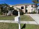 Two-story house with beige exterior, landscaping, and a white mailbox at 25737 Frith St, Land O Lakes, FL 34639